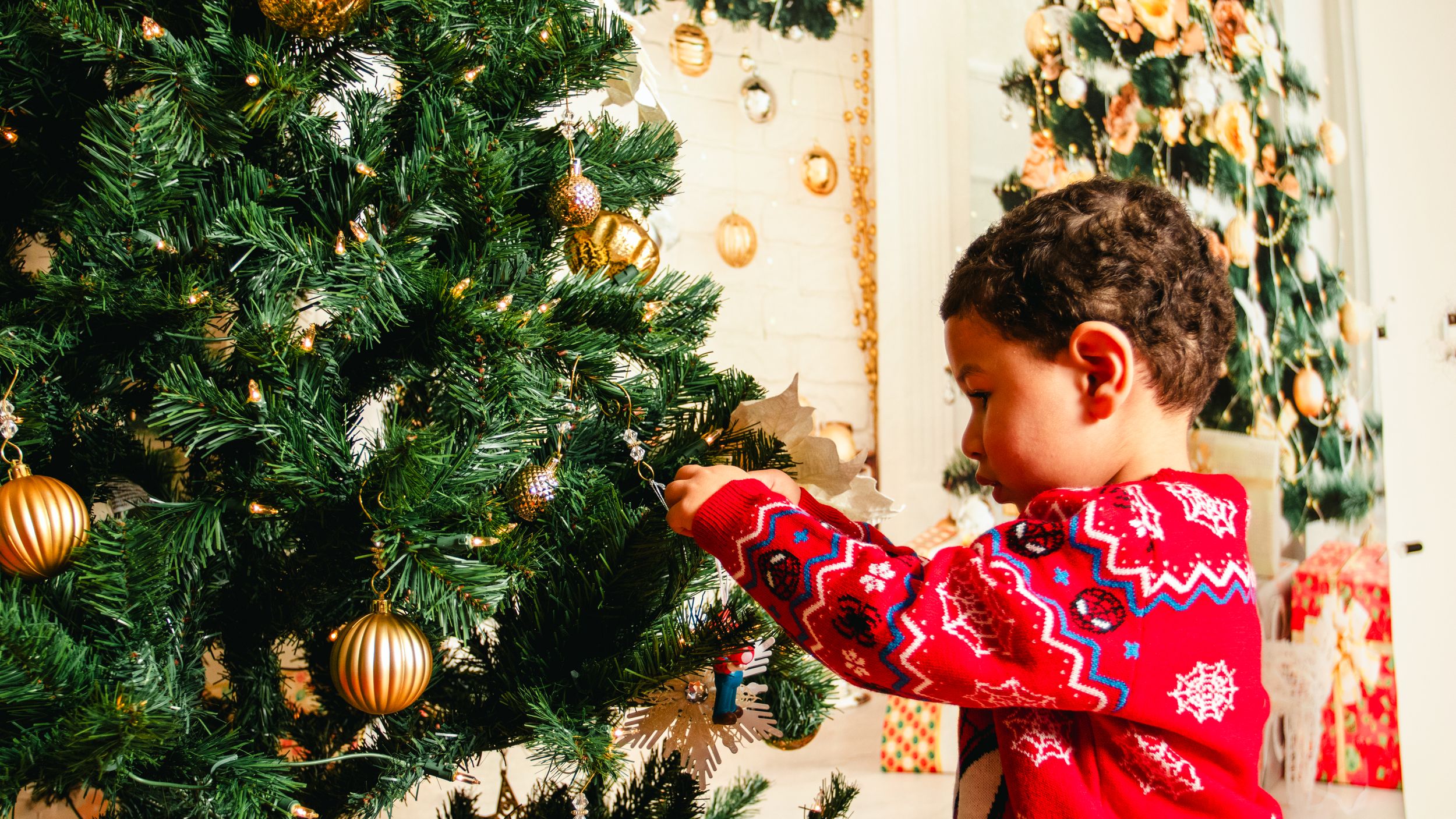 Holiday photo session with decorated Christmas tree and gold ornaments.