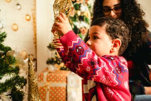 Holiday portrait session with gold star decorations and Christmas tree.