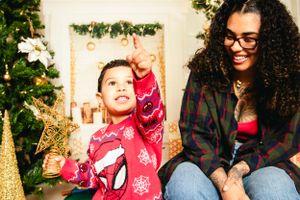 Christmas themed photo session with decorated tree and sparkling gold accents.