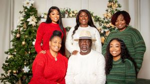 Holiday family portrait with Christmas decorations and festive attire.