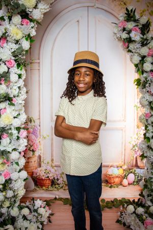 Spring photo session setup with floral arch and decorative elements in soft pink and white tones.