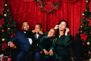 Holiday portrait session with family members in coordinated green and navy outfits.