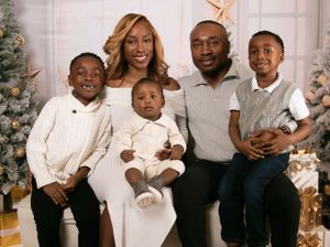 Family portrait session with coordinated white and neutral outfits against winter backdrop.