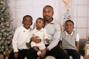 Casual family photo with members wearing coordinated grey and white outfits.