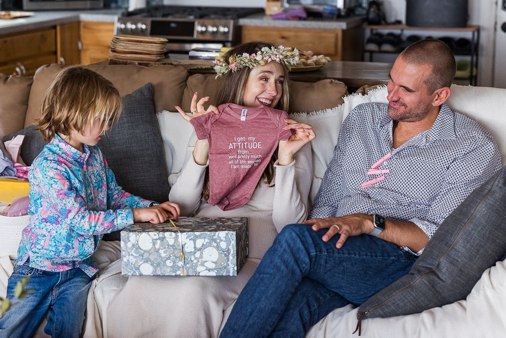 Family moment on grey couch while decorating items from silver box.