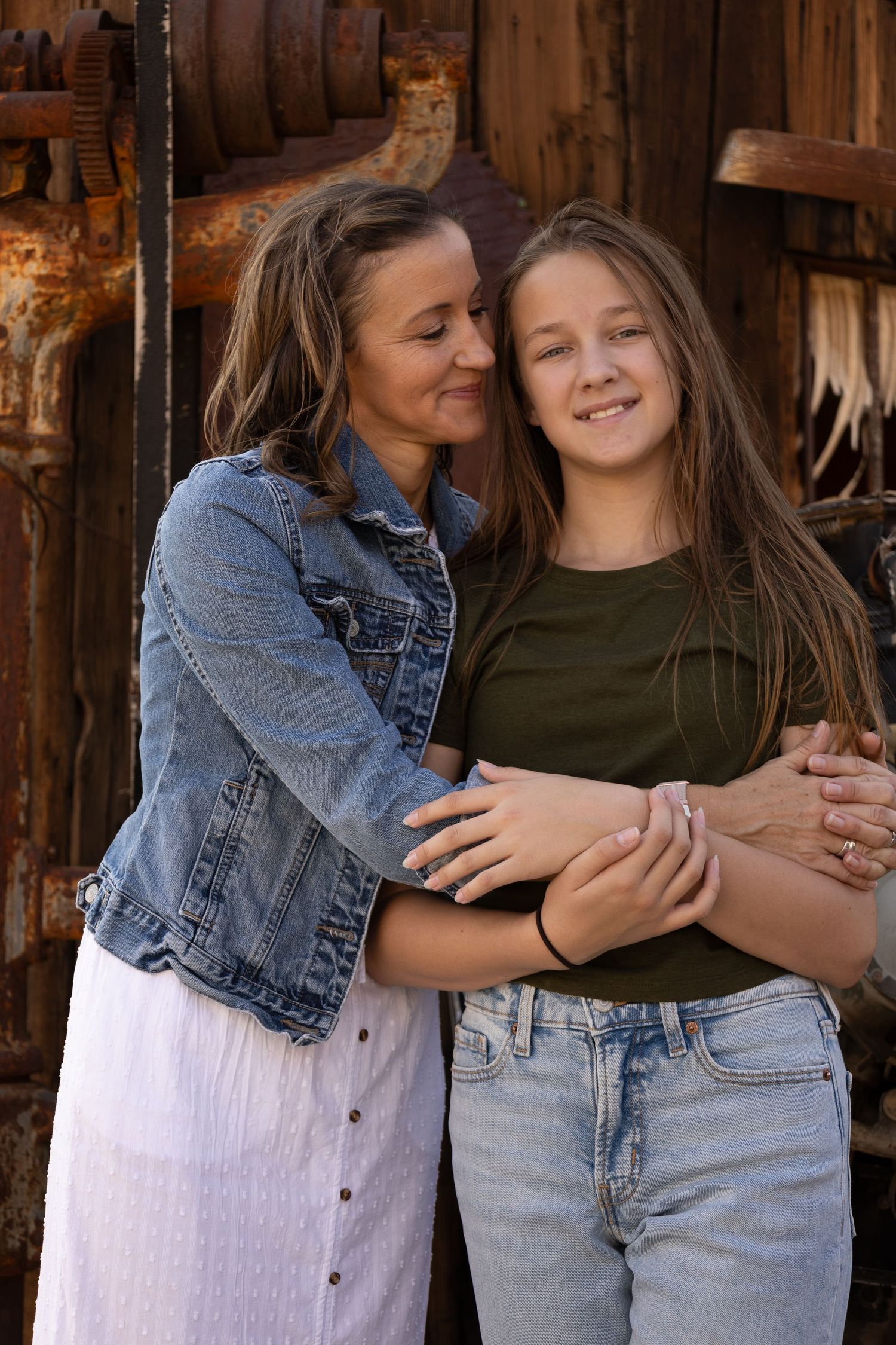 Two people share an affectionate moment against a rustic wooden backdrop.
