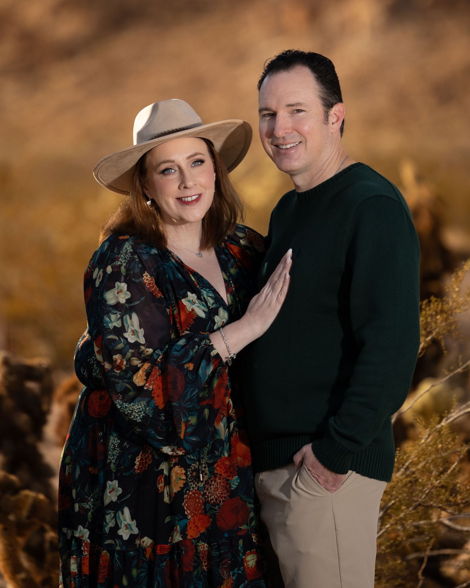 Romantic fall portrait of a couple in western attire against desert mountains.