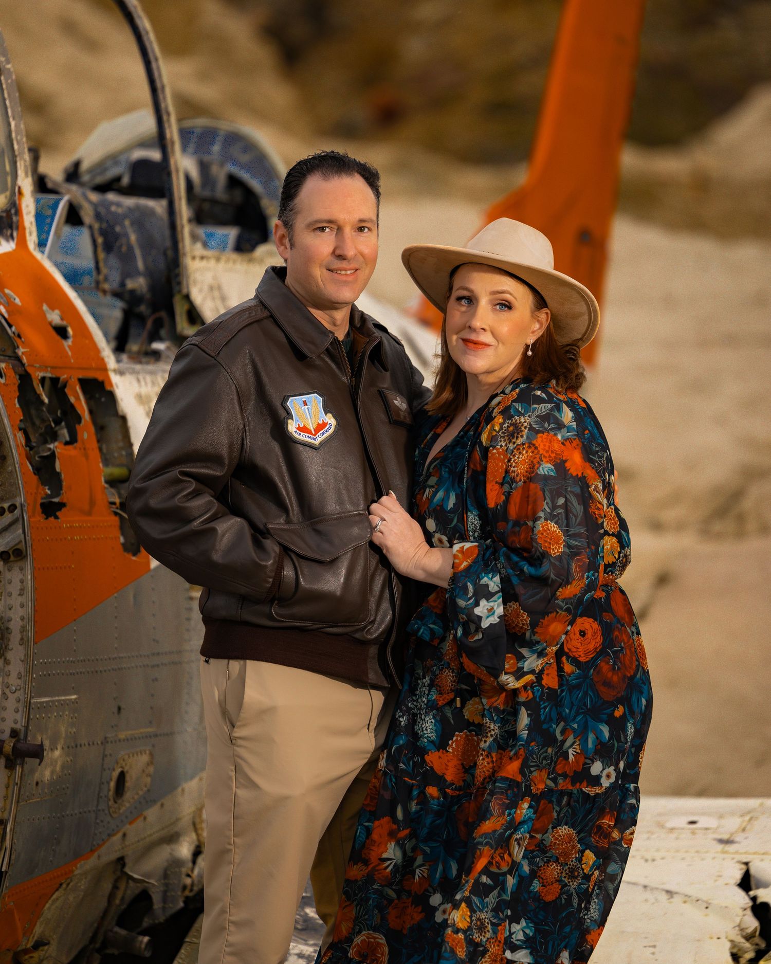 Aviation themed portrait with vintage aircraft and western styled attire.