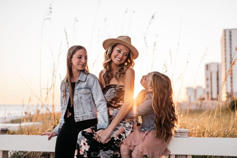 Golden hour sunset photo of a mother enjoying her vacation time with daughters.