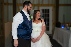 Couple shares an intimate moment in formal wedding attire inside a reception venue.