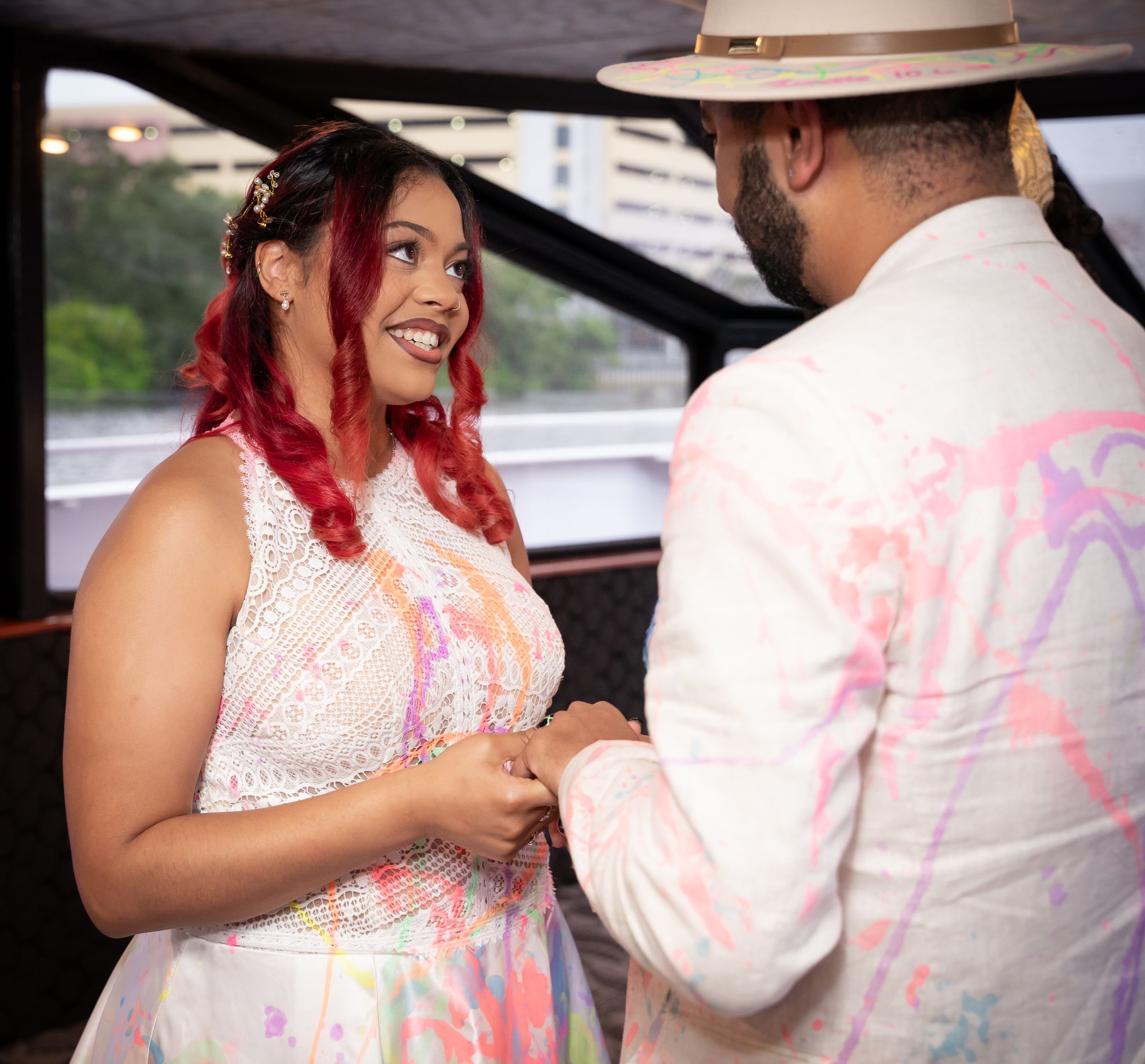 Wedding couple covered in colorful powder engage in playful moments during photo session.