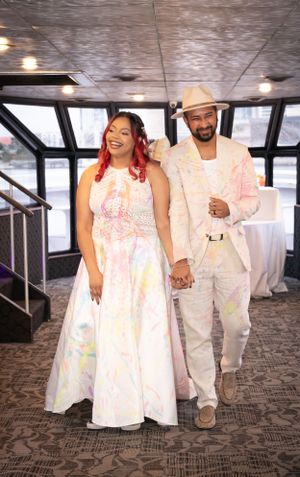 Wedding couple covered in colorful powder walk and dance together during reception.