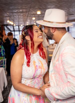 Joyful couple shares intimate moments while covered in vibrant powder paint at their wedding.