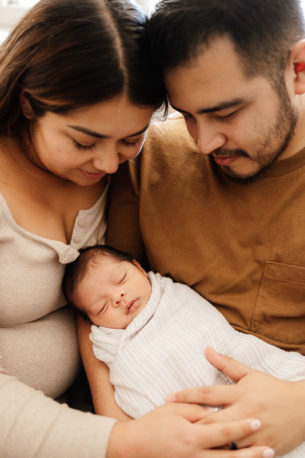 Parents snuggle their new baby at newborn session with Bay Area Newborn Photographer Cindy Tucey in Campbell