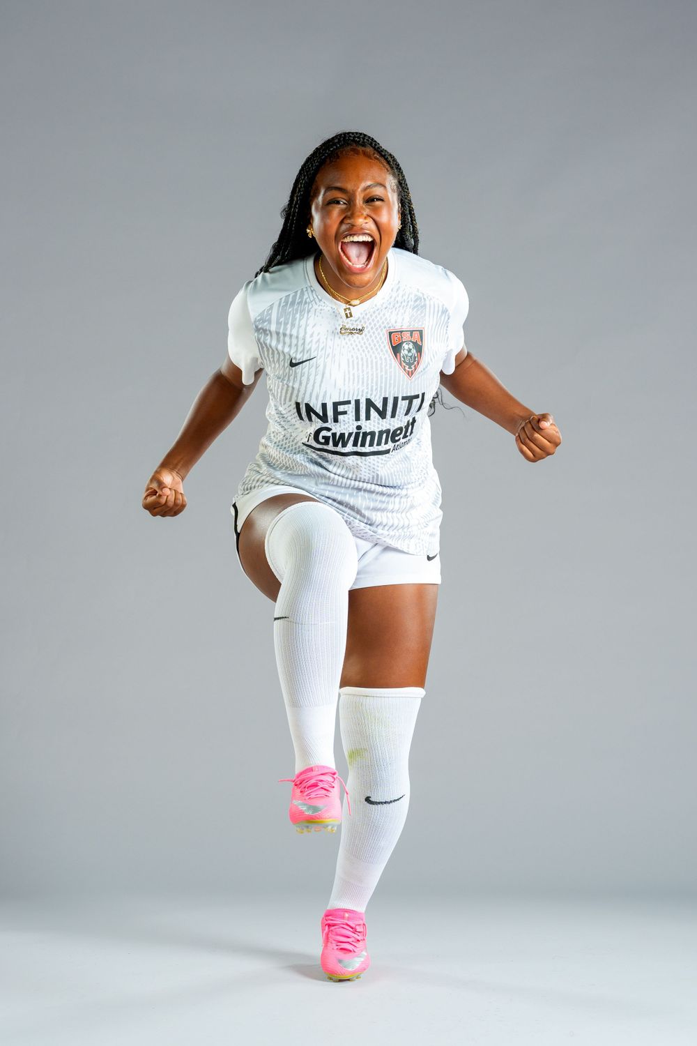 A high school female soccer player screaming with enthusiasm for her media day portrait
