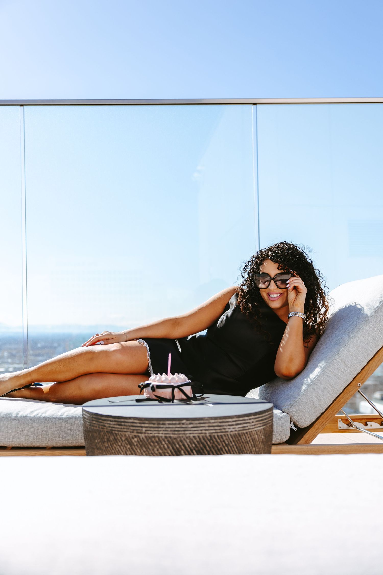 Luxury rooftop lounge scene with city views and cushioned daybed.
