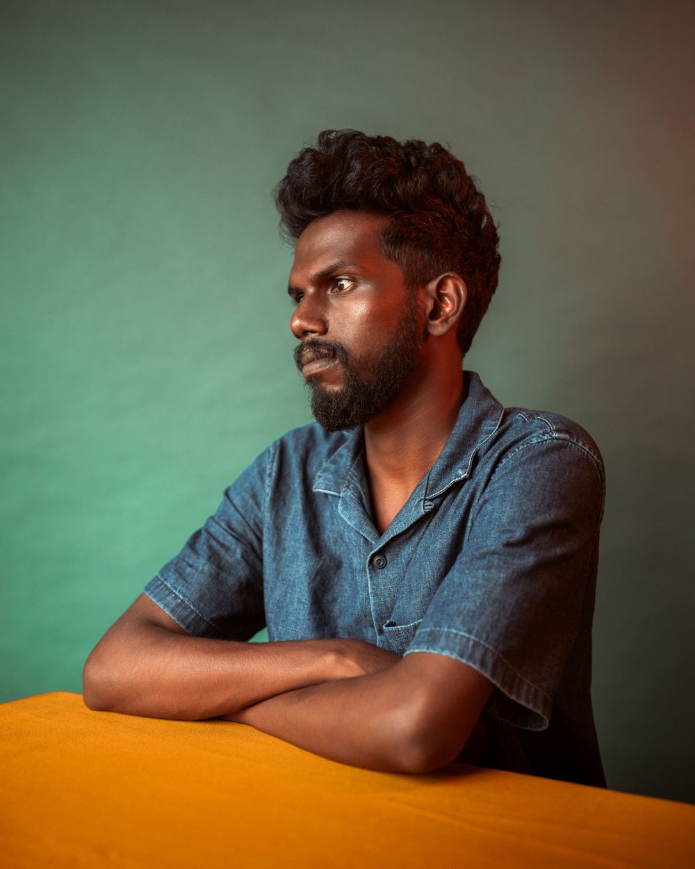 A series of portrait shots showing someone in a denim shirt against a green background.
