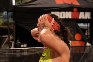 Athlete cools off by pouring water over themselves at an Ironman event.