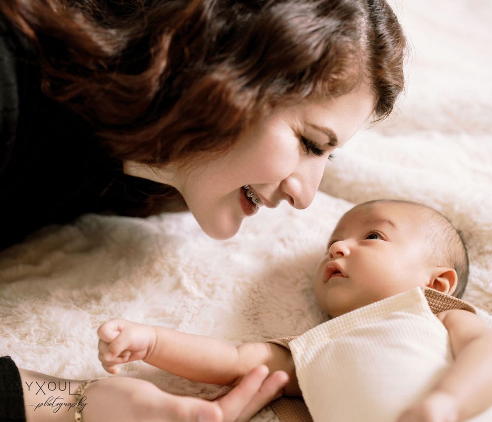 Tender moment between parent and baby captured in soft, intimate portrait.