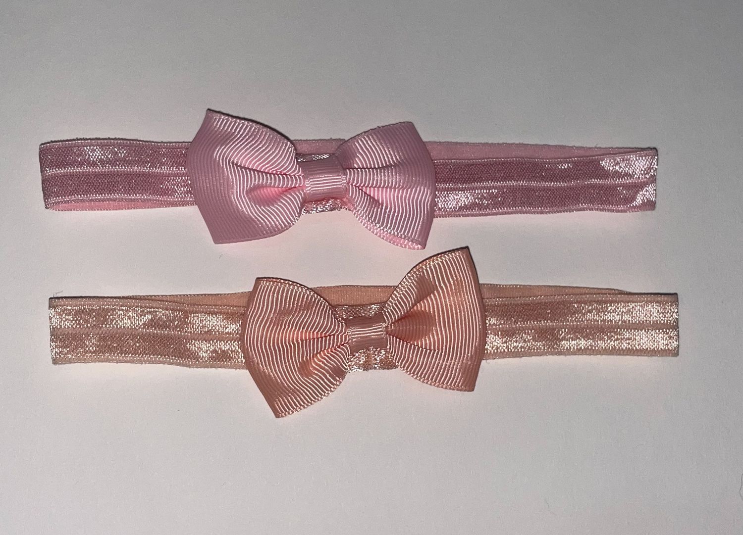Collection of pink and mauve bow ties on elastic bands.
