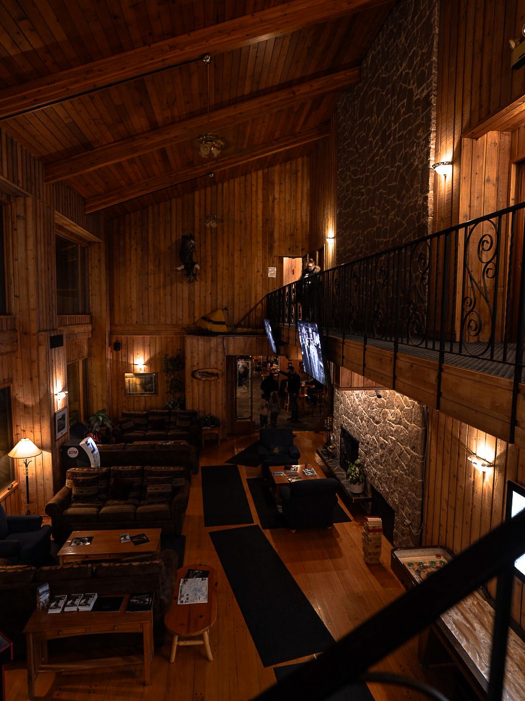 Rustic wooden lodge interior with warm lighting and stone accents.