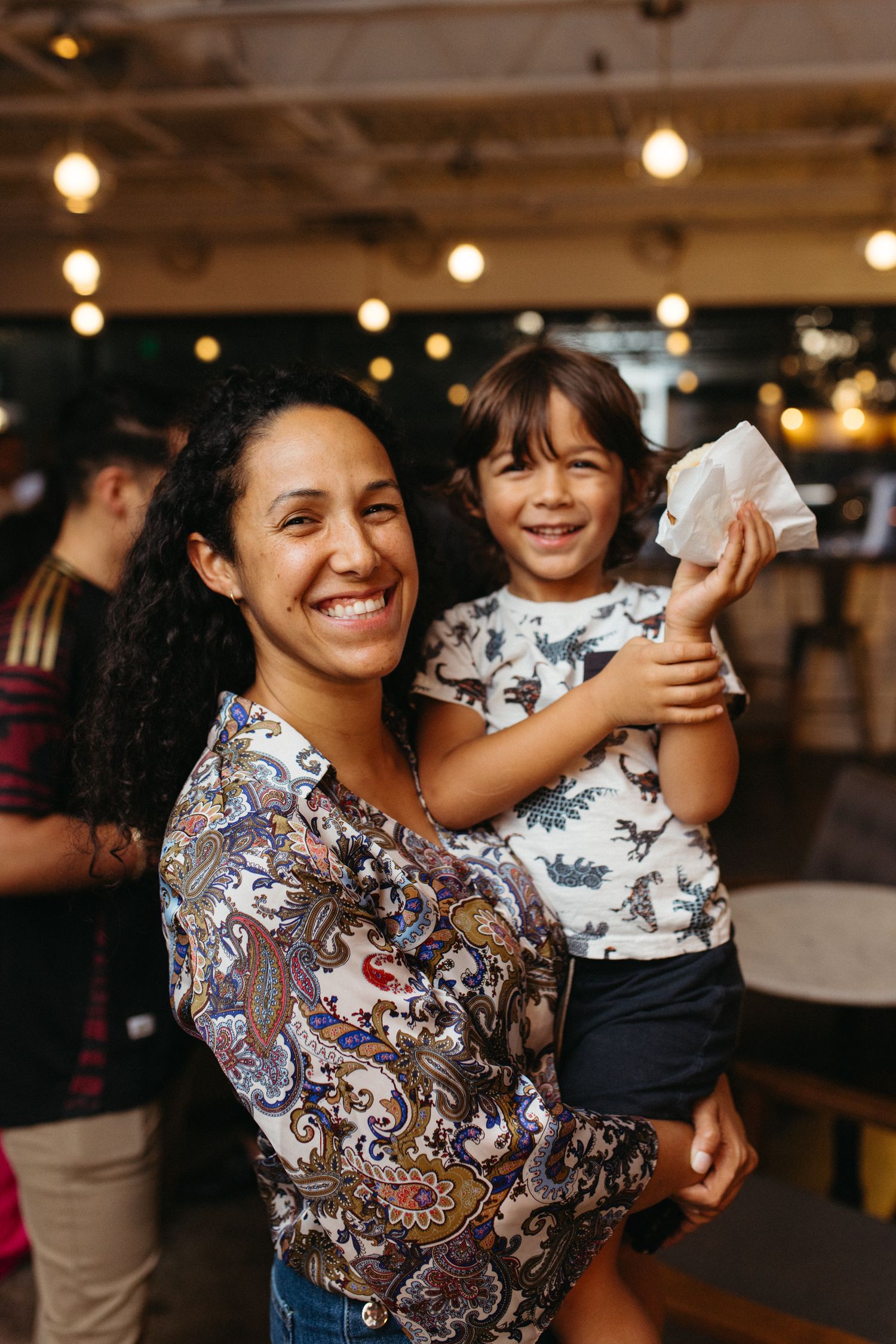 Two people share a joyful moment together in a restaurant with warm lighting and festive atmosphere.