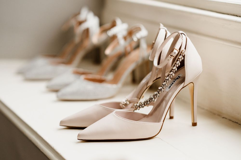 Elegant nude high heeled shoes lined up on a shelf showing bridal wedding footwear details.