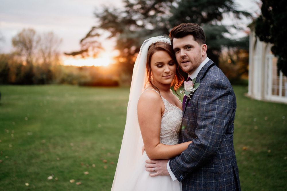 Barton Hall - Romantic sunset portrait of couple in wedding attire on manicured lawn.
