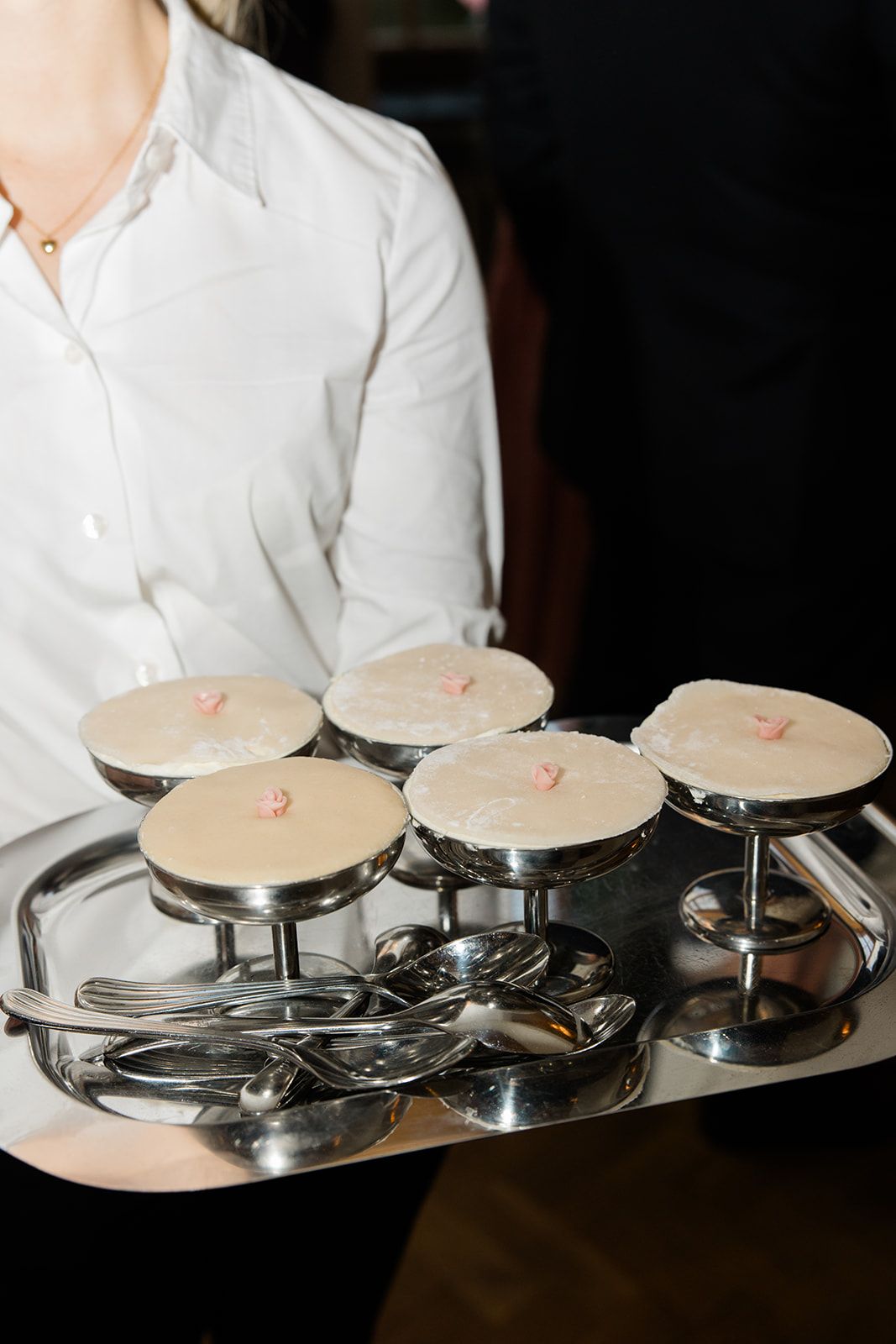 A row of identical white ceramic plates on metal stands are arranged in a professional restaurant setting.