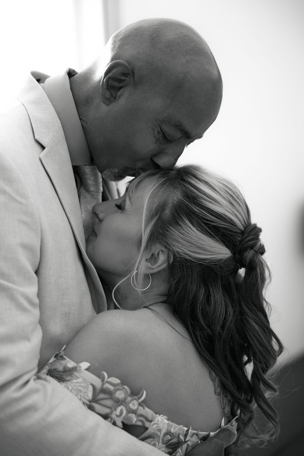 Black and white intimate portrait of newlyweds sharing a romantic moment.