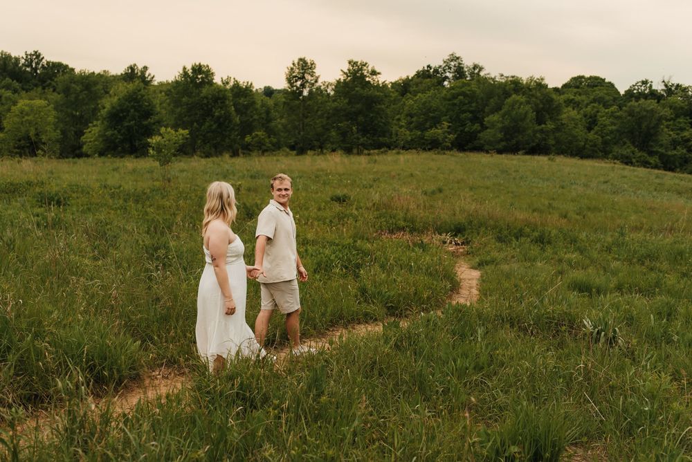 Engaged couple holding hands and smiling during their engagement session.