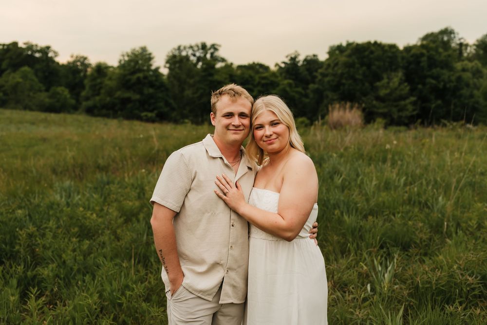 Engaged couple holding hands and smiling during their engagement session.