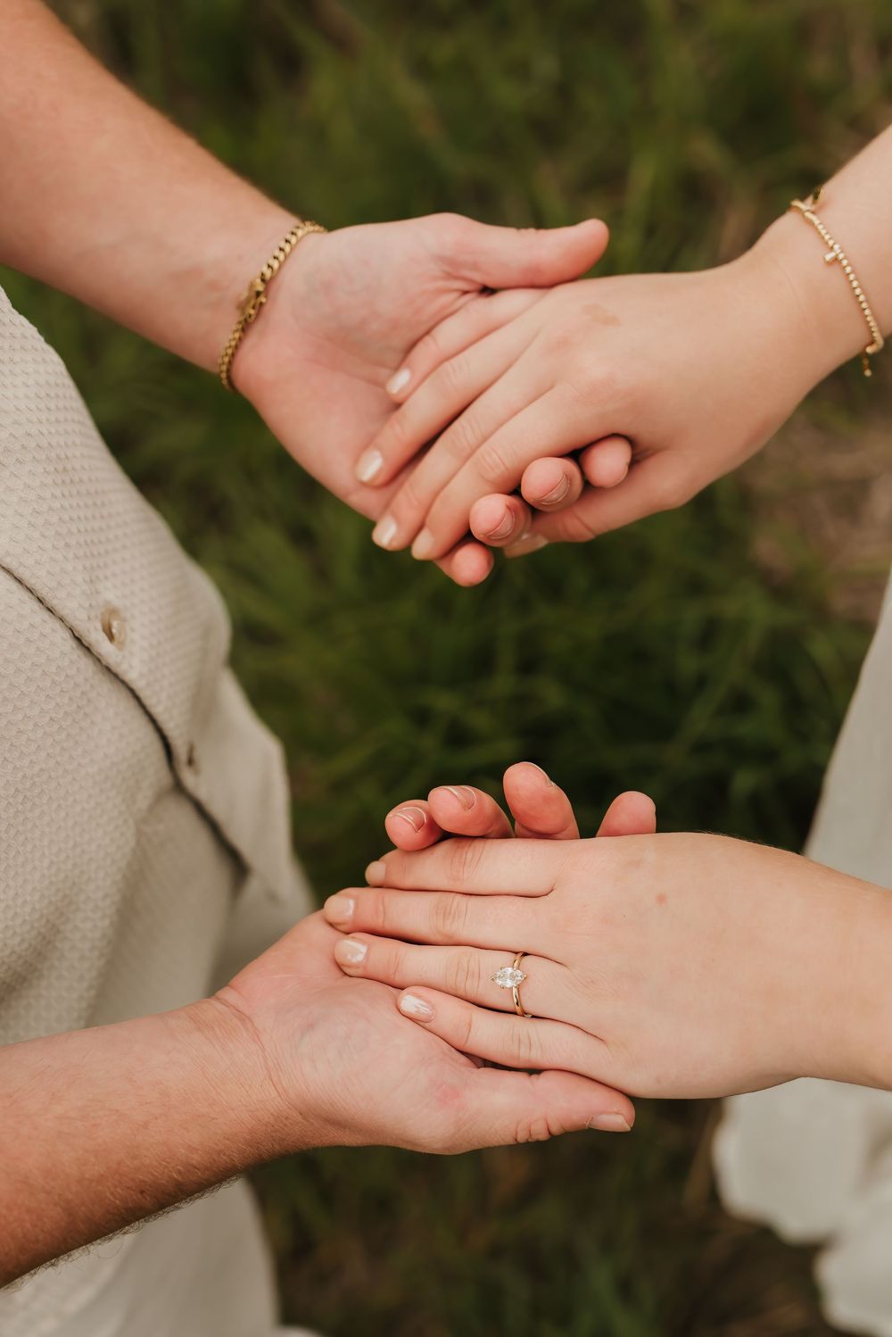 Romantic engagement photo of couple cuddling in soft golden hour light.