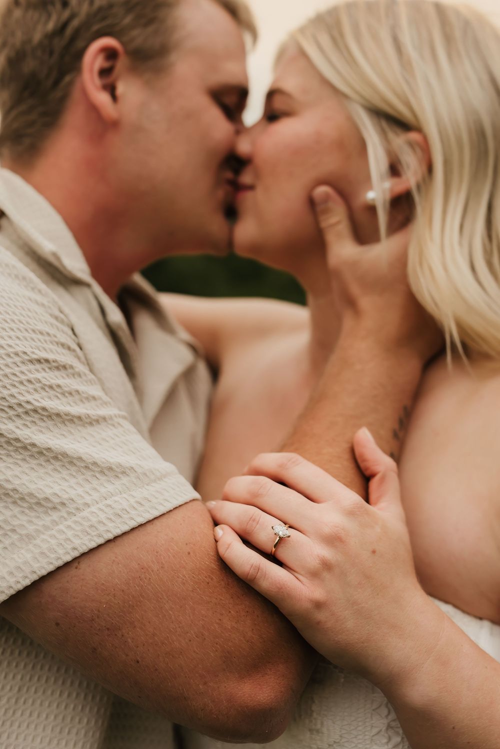 Couple laughing together during a candid engagement session outdoors.