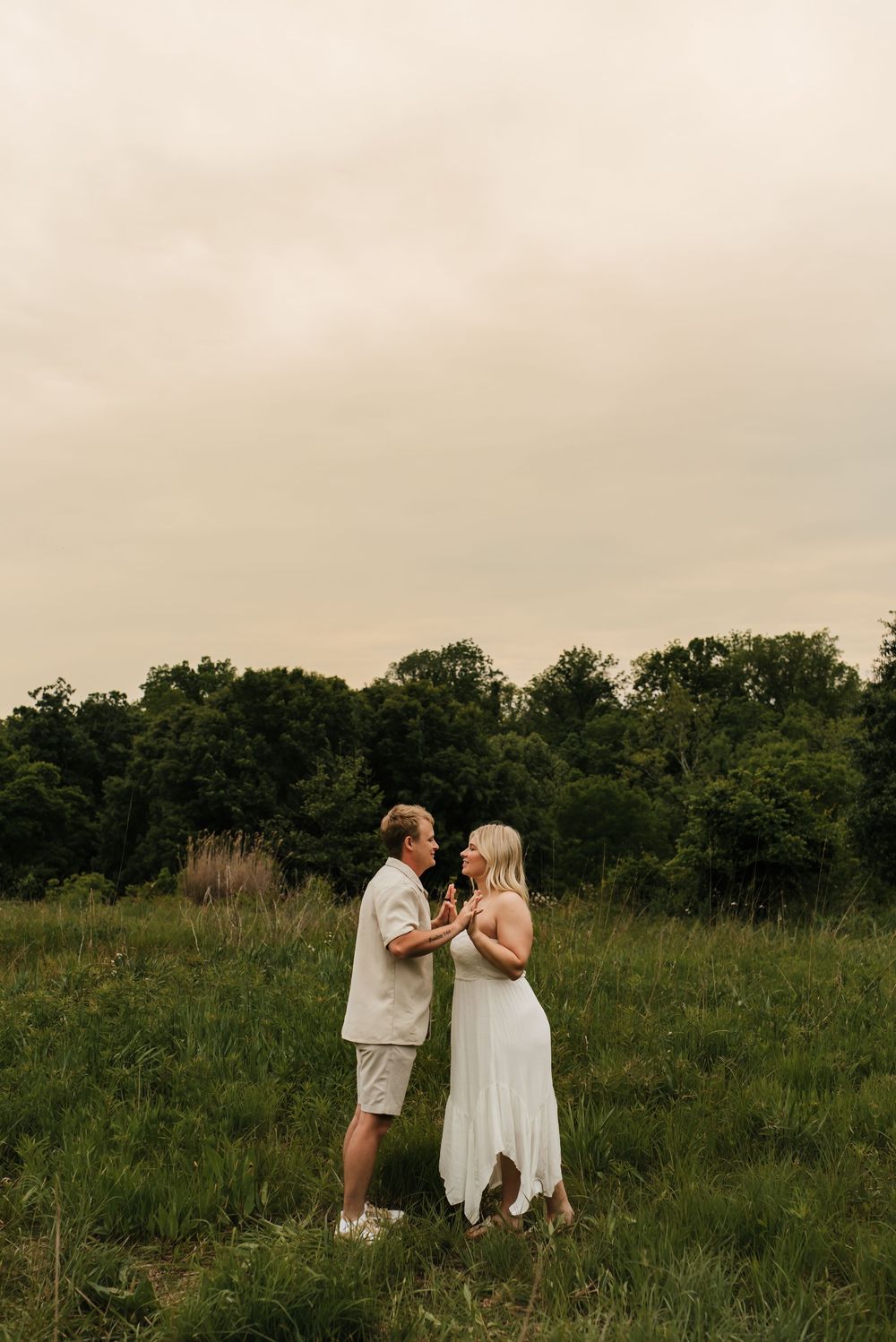 Couple laughing together during a candid engagement session outdoors.