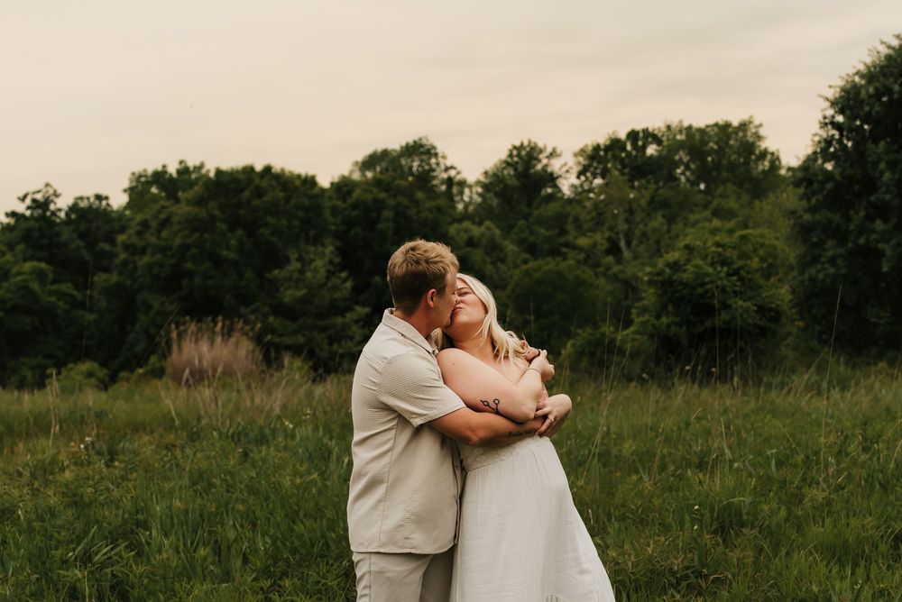 Couple laughing together during a candid engagement session outdoors.