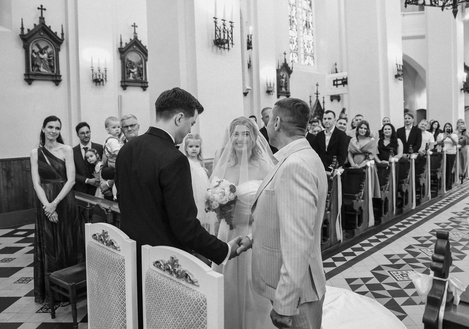 A series of black and white photographs showing moments from a traditional Catholic church wedding ceremony.