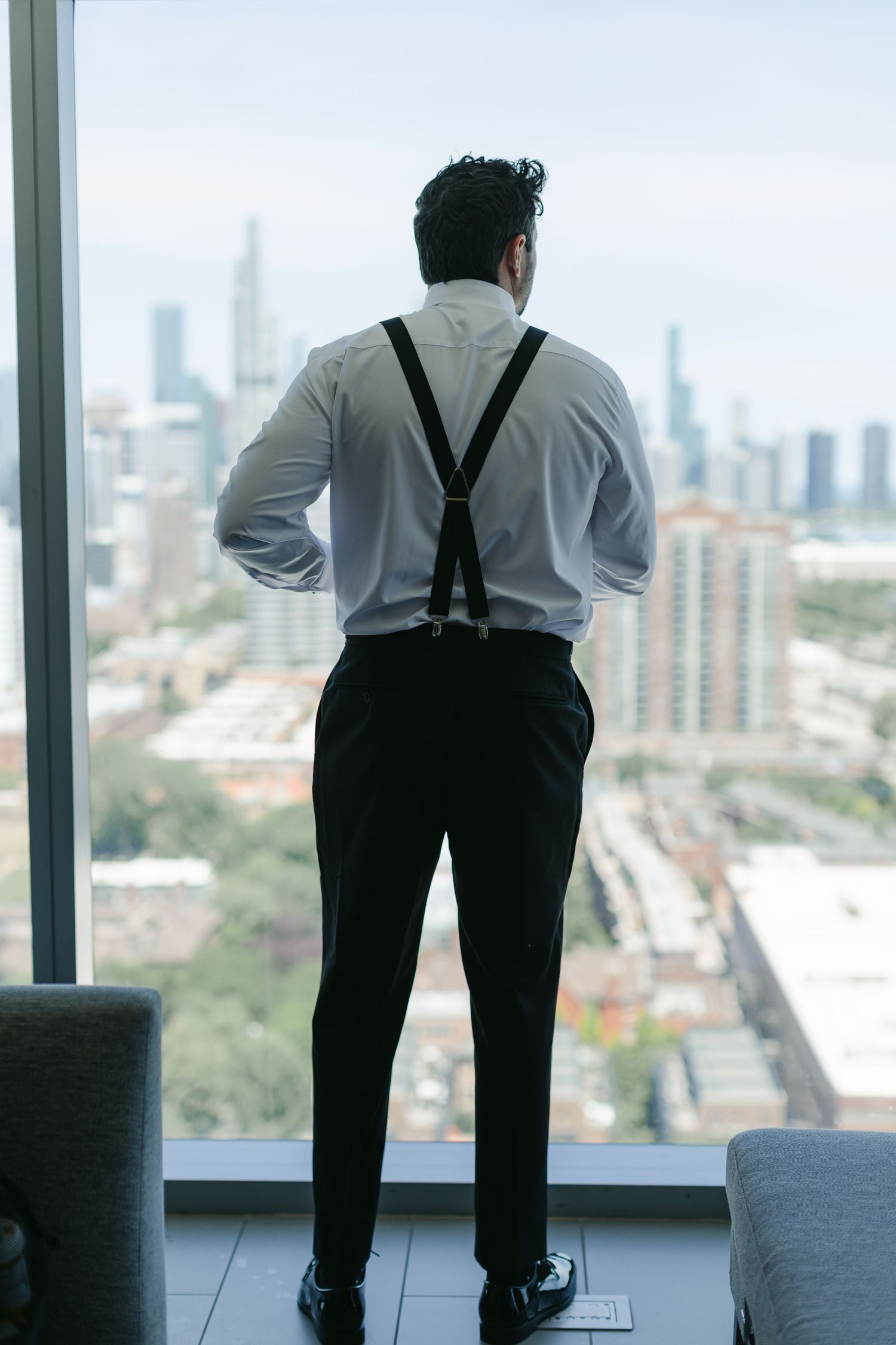 Person in business attire gazes at city skyline through large office windows in a sequence of views.