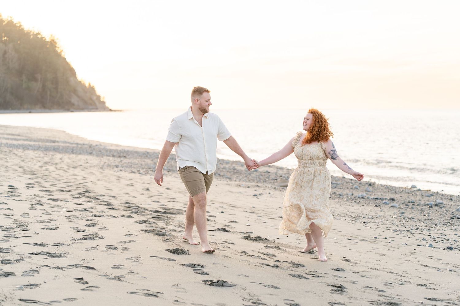 A couple shares tender moments together while sitting in tall golden grass during a romantic outdoor photo session.