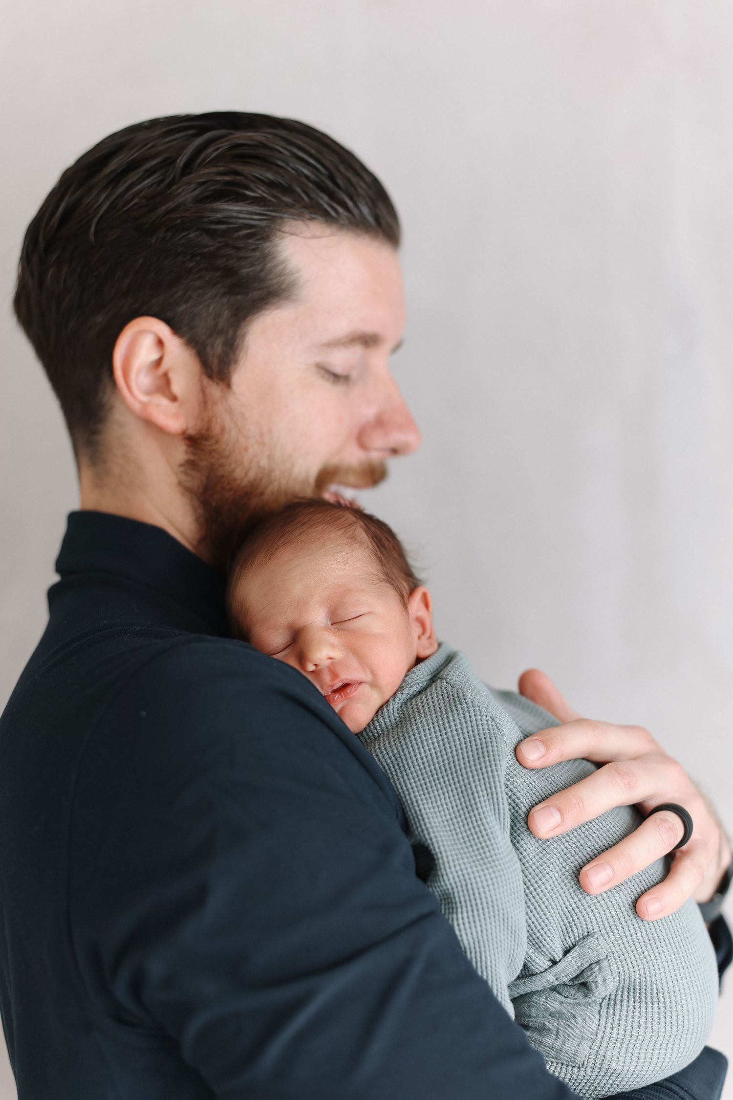 A tender moment between parent and newborn baby shown in four sequential photos against a light background.