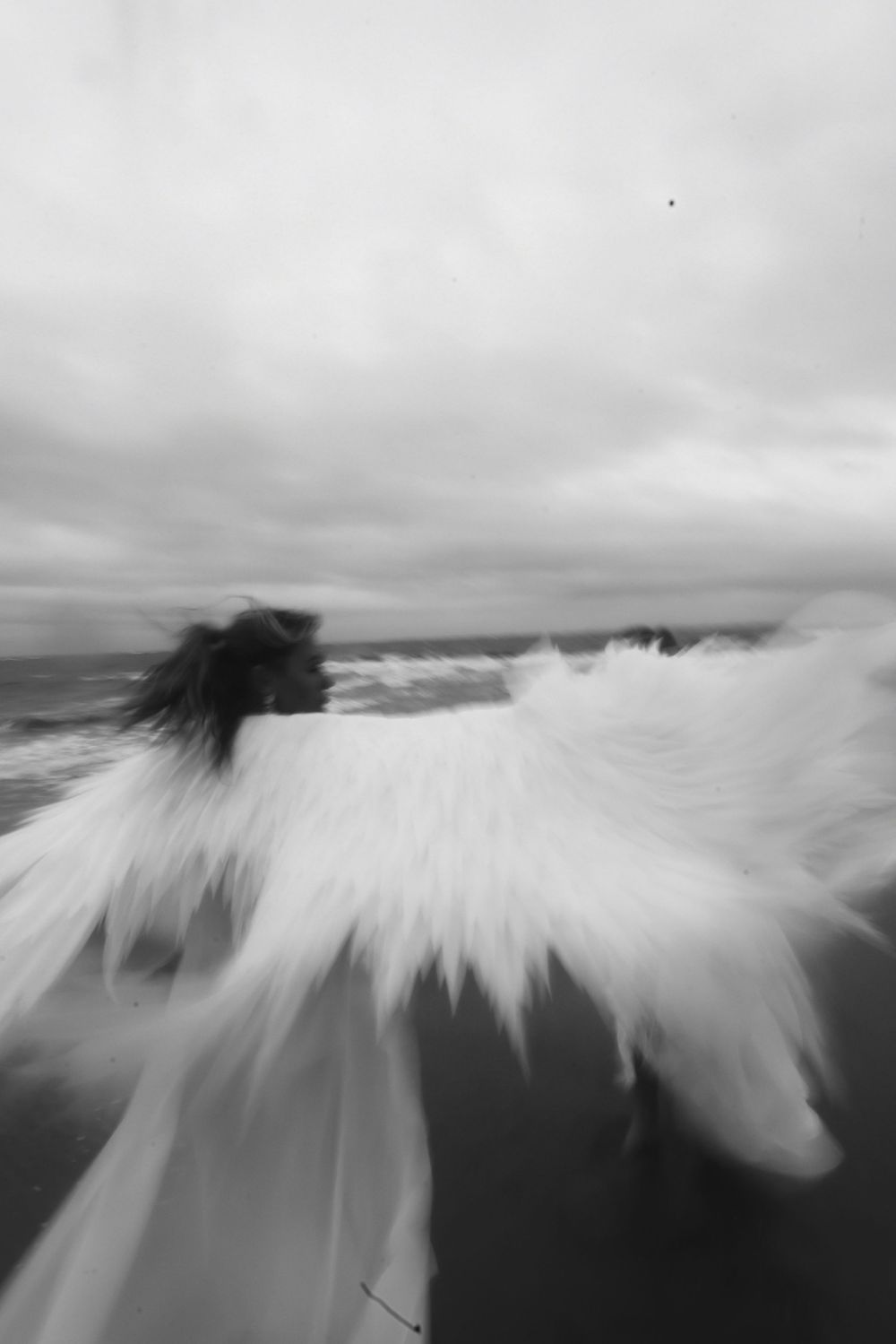 Black and white panoramic sequence showing ocean waves crashing against rocks with dramatic motion blur effect.