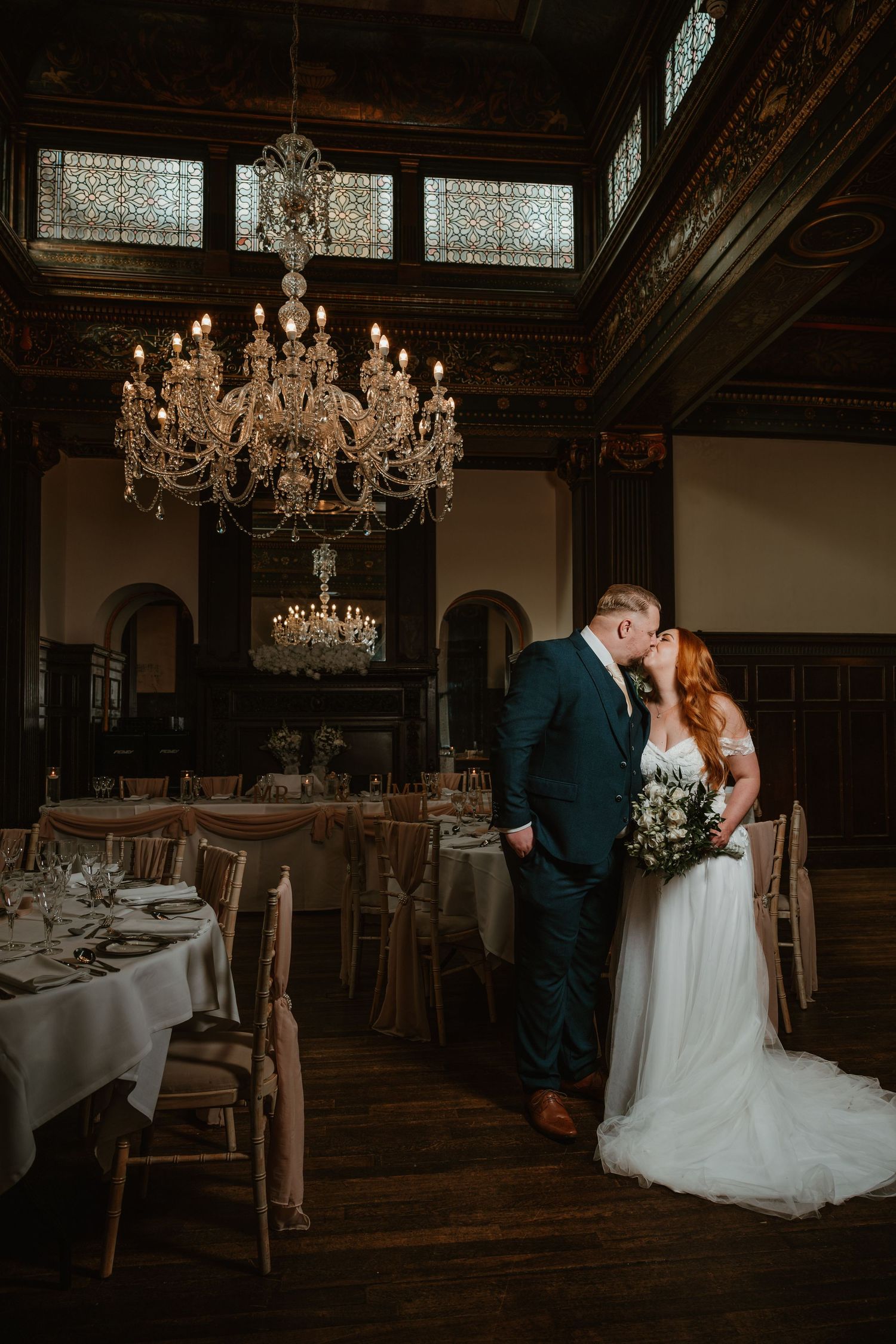 A romantic wedding scene with a couple sitting together in a cozy, dimly lit rustic room with elegant decor at Wortley hall, by Daniel Berry