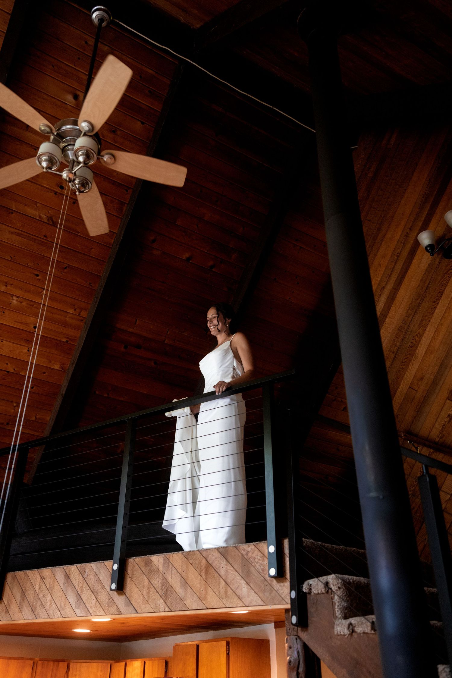 A rustic wooden venue interior with exposed beams and ceiling fans creates an elegant wedding atmosphere.
