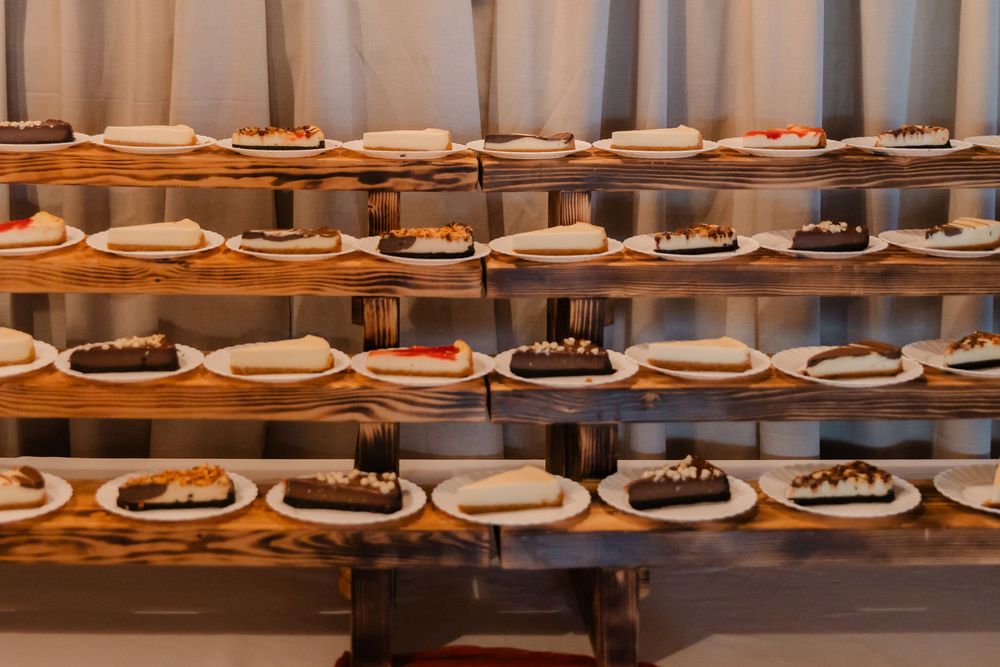 Long wooden table displays rows of plated chocolate desserts and cakes in an upscale restaurant setting.