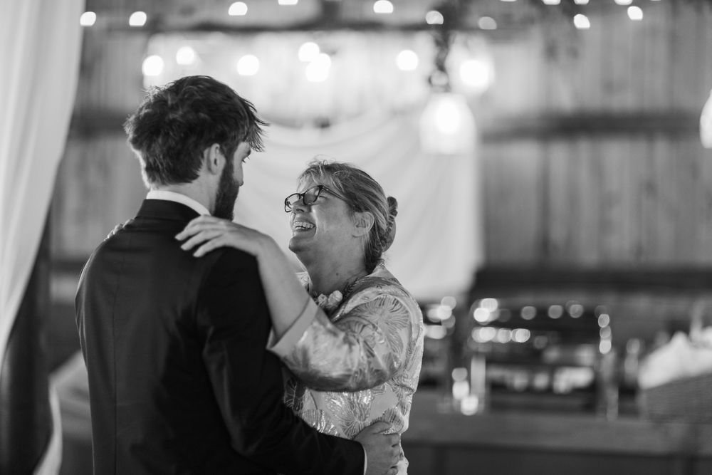 Couples dance together in a dimly lit ballroom with twinkling lights overhead during an elegant evening event.