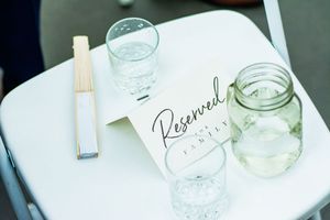 Mason jars and elegant wedding decor details arranged on a white surface.