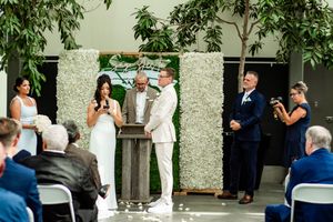 Wedding celebration in a lush garden setting with greenery and decorative elements.