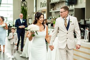 Wedding celebration in a bright indoor venue with elegant decor and natural lighting.