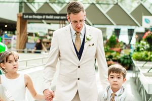 Wedding party members in cream colored suits walking together.