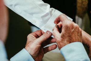 Close-up shots of hands folding and preparing white paper or napkins for a formal event.